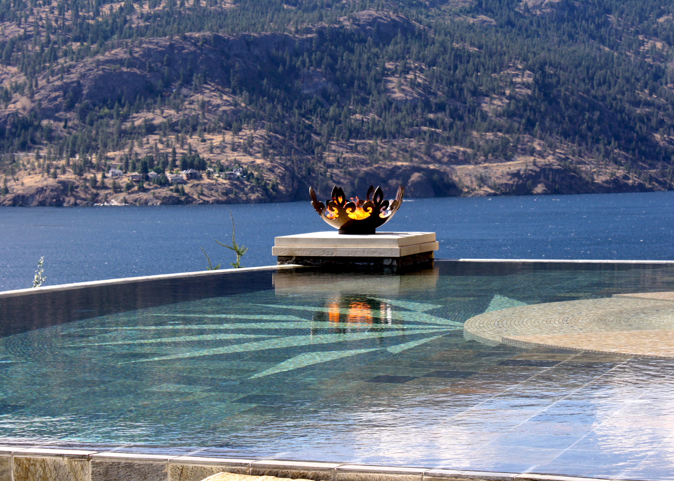 Fiery Fleur-de-lis 37 Inch Sculptural Firebowl™ Flanking Infinity Pool Over Lake Okanagan