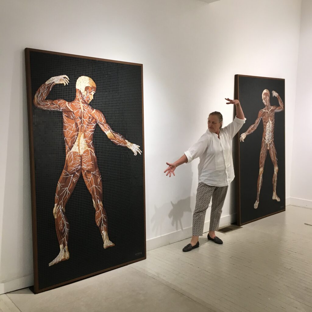Gallerist Carrie Haddad poses to mirror the figure in a marble mosaic at the Anatomy Set in Stone exhibition, Carrie Haddad Gallery, Hudson New York, 2019
